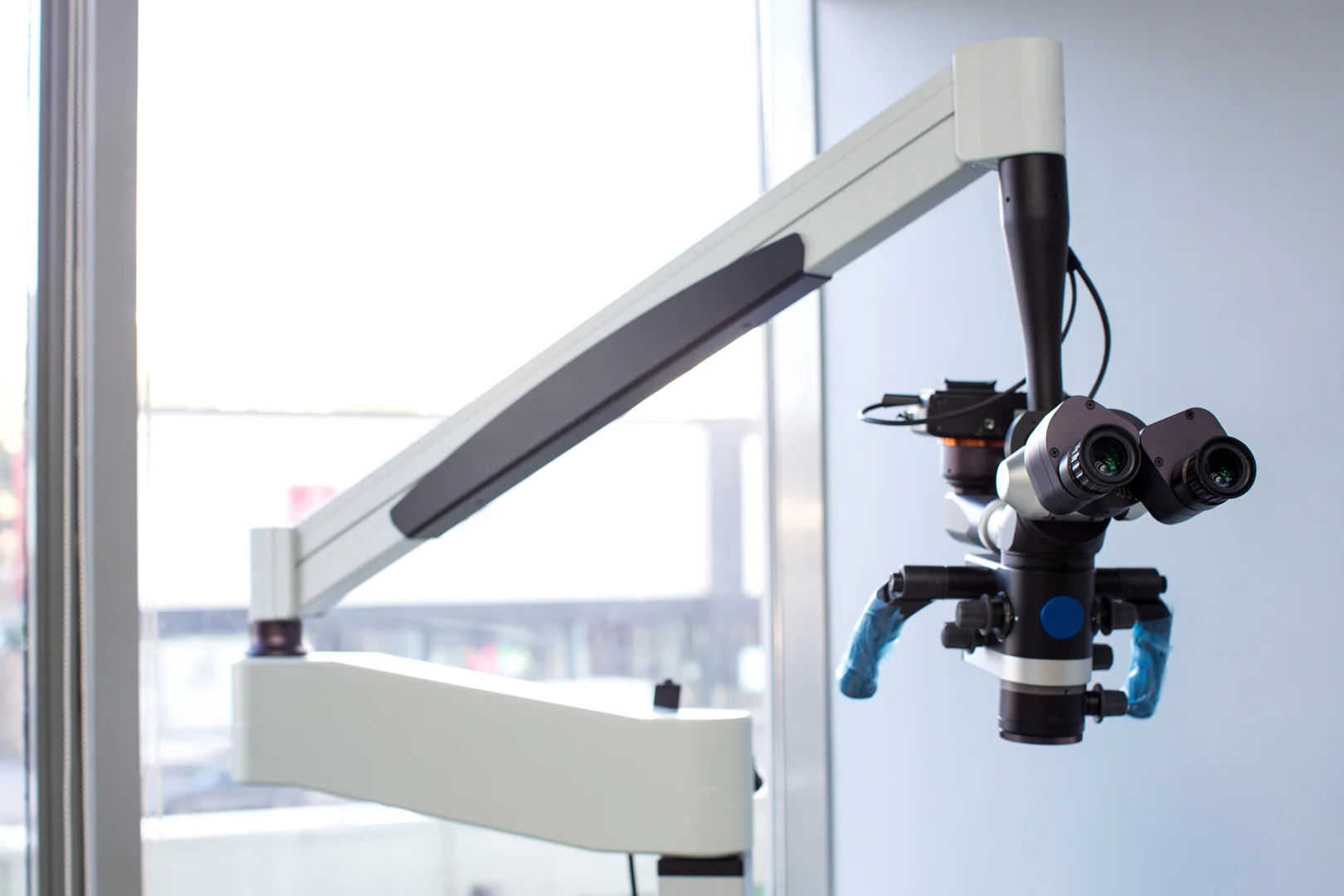 Microscop chirurgical oftalmologic montat pe braț articulat, în sala de operație